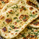 Crispy garlic naan bread recipe with golden bubbles and fresh herbs